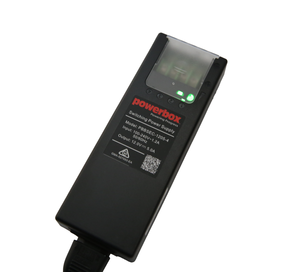 Powerbox PBBSEC-1205-4 security power supply with clear fuse cover, green status LEDs and mains lead.